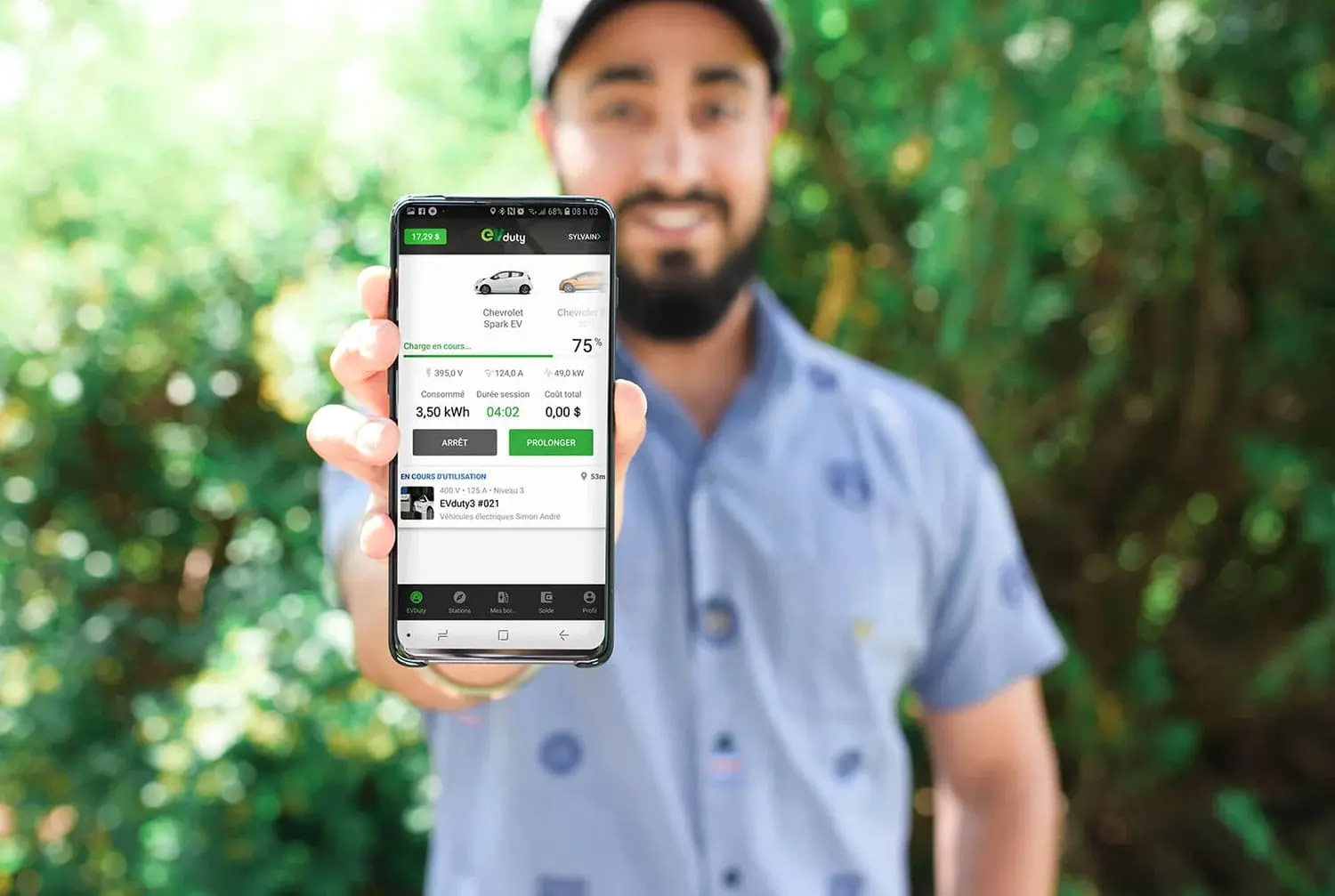 un homme tenant son téléphone portable en l'air tout en montrant son application EV Duty